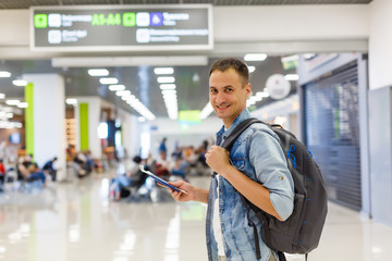 portrait of a happy male traveler walking with backpack