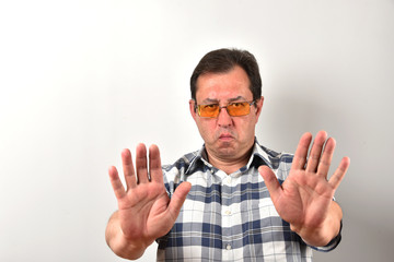 Portrait of a mature man in glasses, a plaid shirt on a white background. Emotions and gestures.