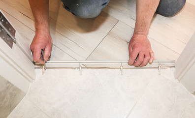 Installation of threshold indoors. Renovation works in the flat.