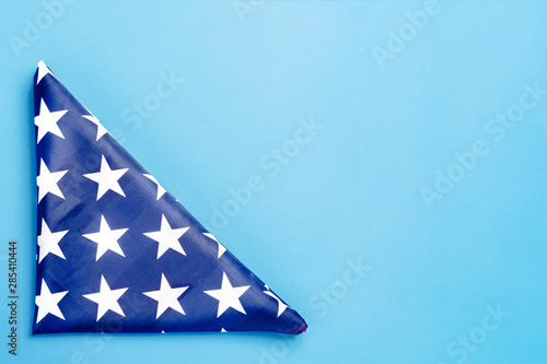 Folded USA flag on a blue background. Concept Memorial Day, Independence Day, July 4th. Flat lay, top view