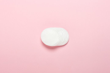 Cotton hygienic discs for makeup on a pink background. Makeup and hygiene concept. Flat lay, top view
