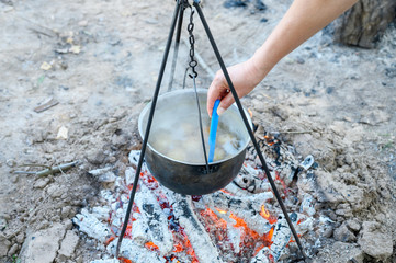 potatoes are cooked in a pot over the fire