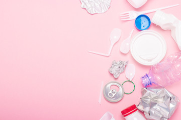 Garbage collection, plastic and metal on a pink background. Concept stop plastic, recycling, separate collection of garbage. Flat lay, top view