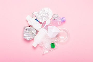 Garbage collection, plastic and metal on a pink background. Concept stop plastic, recycling, separate collection of garbage. Flat lay, top view