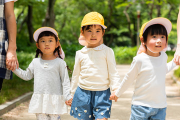 公園を散歩する保育士と園児