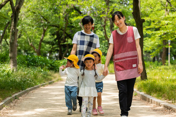 公園を散歩する保育士と園児