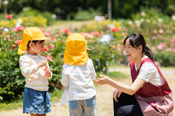 公園で遊ぶ保育士と園児たち