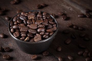 coffee beans in brown bowl on the brown wood table.