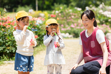 公園で遊ぶ保育士と園児たち
