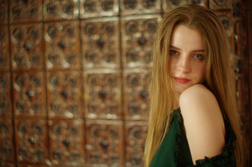 Fototapeta na wymiar beautiful young blonde with long flowing hair and blue eyes in an old castle