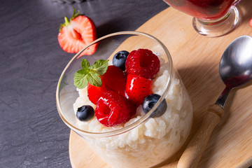 delicious milk rice with different berries and red fruit jelly
