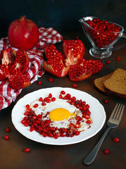 Traditional Azerbaijan cuisine pomegranate with egg narnumru on white plate on black background,top view,close-up