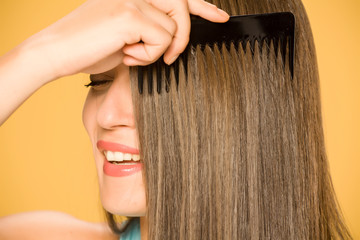 Closeup of happy woman combing her hair