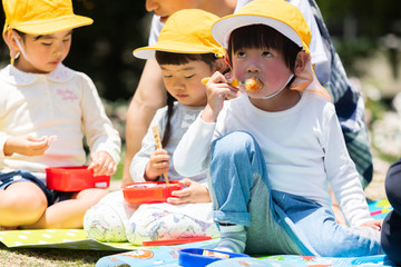 公園でお弁当を食べる園児