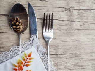 Festive setting for christmas or thansgiving holiday dinner. Vintage cutlery on the white napkin on old wooden background with copy space