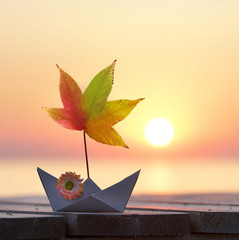 Papierboot mit Laubblatt am Meer