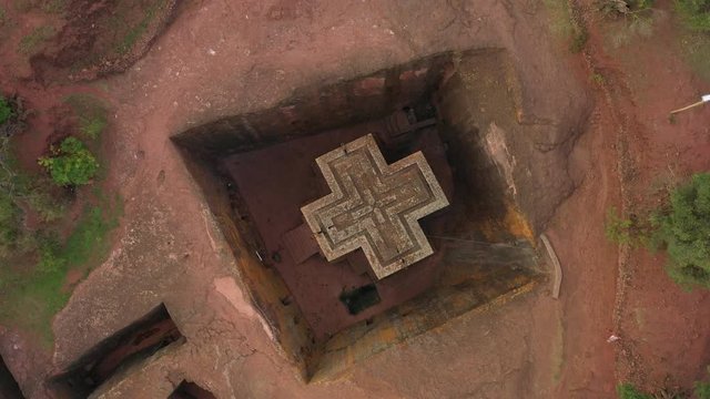 Overhead rotating drone shot of Christian Orthodox monolithic church in Lalibela, historic monument in Northern Ethiopia