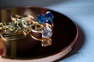 Golden ring with diamonds. Female jewelry on a table, close up.