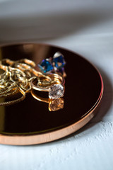 Golden ring with diamonds. Female jewelry on a table, close up.