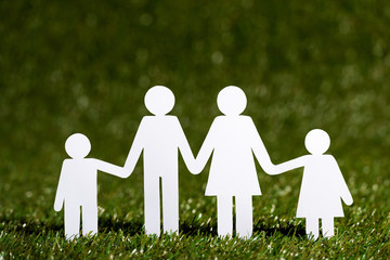 Paper cut of family on the artificial grass