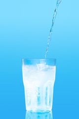Close up pouring purified fresh drink water from the bottle on table