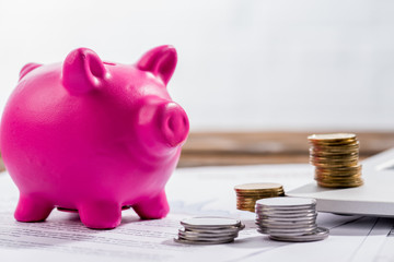 Pink piggy bank and coins on the table