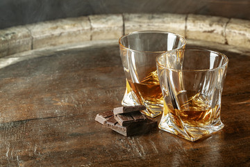 Two glasses of bourbon or scotch, or brandy and pieces of dark chocolate