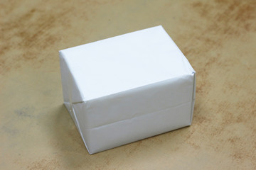 Closed white paper box on wood background