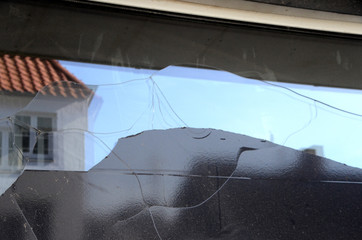 Thermal fracture in a shop window, due to coverage with black plastic foil that has caused overheating of the glas. Vandalism would have shown impact points.