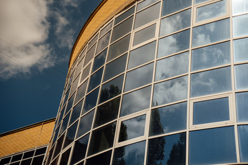 windows of modern office building. Modern architecture bank financial office tower building. clouds and bright blue sky reflected in the square mirrored windows of a modern commercial office building