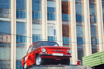Old red vintage car in the background of the building