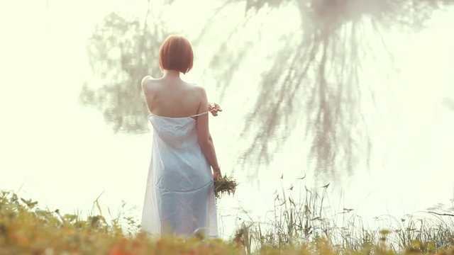 Footage of pretty girl get undressed by the lake