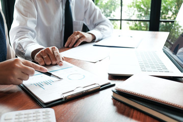 Businessman analyzing investment charts and pressing calculator buttons over documents. Accounting Concept.