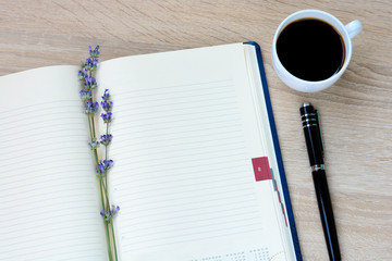 Notepad, pen, flowers (lavender)  on a wooden desk. Writer;