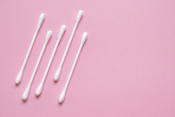 Flatlay white cotton buds for ears on pink with space for text. Concept of hygiene, medicine, health care, beauty