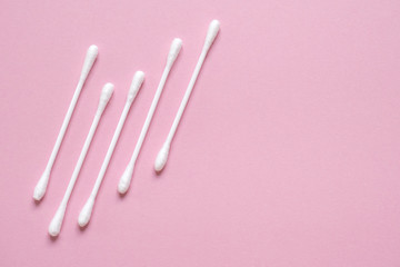 Flatlay white cotton buds for ears on pink with space for text. Concept of hygiene, medicine, health care, beauty