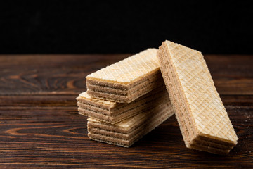 Vanilla wafer biscuit on dark wooden background.