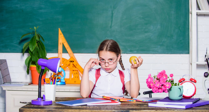 Vegetarian. back to school. Einstein. digital age with modern technology. small girl ready to eat apple. Smart child concept. healthy eating is good. small genius child in classroom. Lunch time