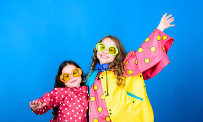 family bonds. Small girls in raincoat and glasses. happy small girls in colorful rain coat. rain protection. Rainbow. autumn fashion. cheerful hipster children, sisterhood. having fun. Totally free