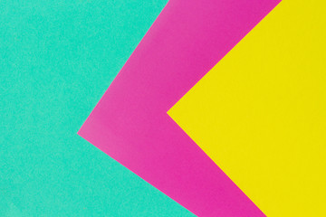 Abstract geometric paper background. Neon gradient of mint, purple, and yellow trendy colors. Geometric vibrant colors textured flat lay.
