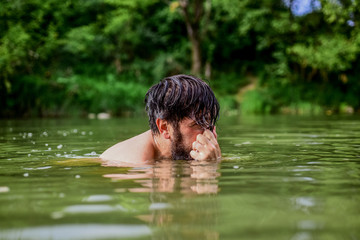 Deep dangerous water. Submerge into water. Freshness of wild nature. Summer vacation. Relaxation and rest. Swimming sport. Swimming skills. Refreshing feeling. Man enjoy swimming in river or lake