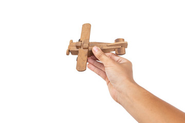 Hand holding wooden toy plane hand on white background.