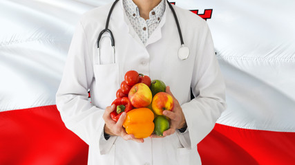 Doctor is holding fruits and vegetables in hands with Gibraltar flag background. National healthcare concept, medical theme.