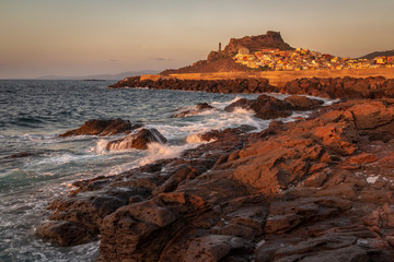 Sunset over rocky beach near Castelsardo, Sardinia, Italy