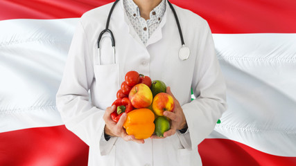 Doctor is holding fruits and vegetables in hands with Lebanon flag background. National healthcare concept, medical theme.