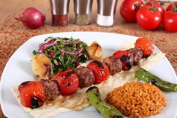 Meat and tomato kebabs with fresh and vegetables