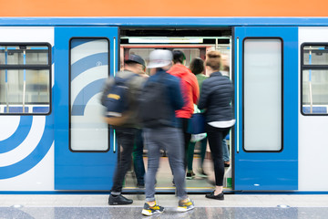 Passenger flow concept. People go on subway train. Passengers are blurred, movement is shown. Train...