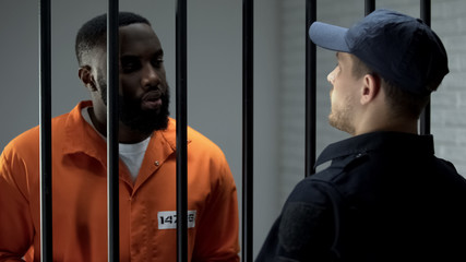 Afro-american prisoner making arrangement with prison guard, corruption in jail