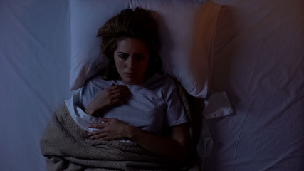 Annoyed woman suffering insomnia at night, uncomfortable sleeping conditions
