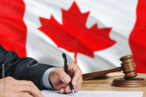 Judge Writing On Paper In Courtroom With Canada Flag